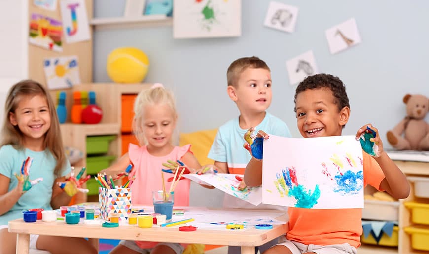 Kinder bemalen ihre Hände mit Fingerfarbe und stempeln sie auf Papier